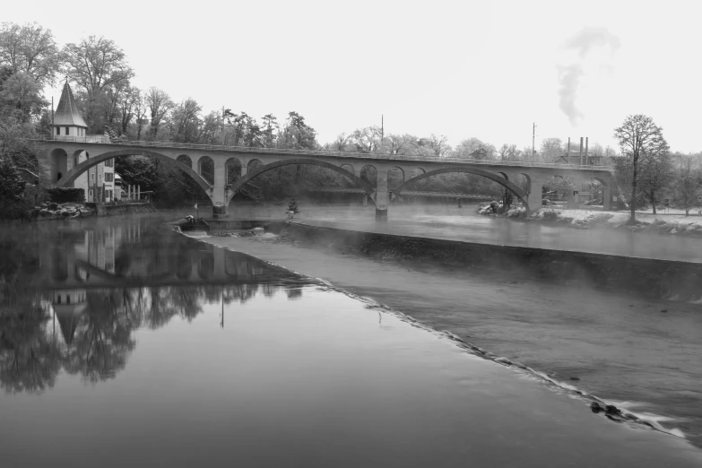 the old bridge and surrounding buildings are reflecting the water