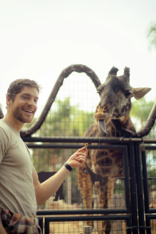 the man is feeding his friend the giraffe