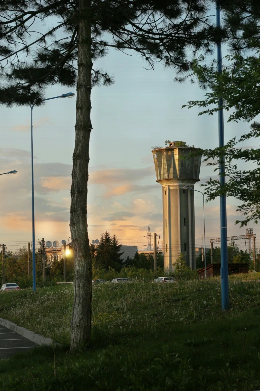 the clock tower in the field is under the sunset