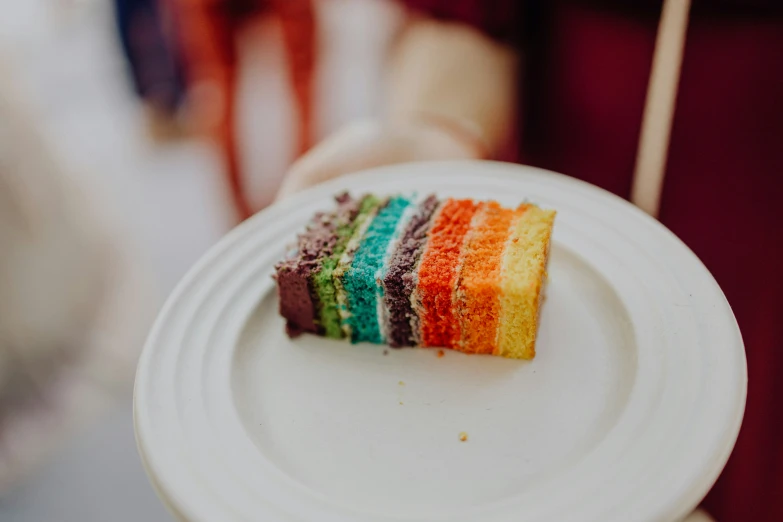 there is a slice of rainbow cake on a plate