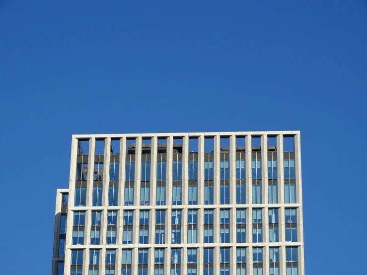 a blue bus is parked in front of the tall building