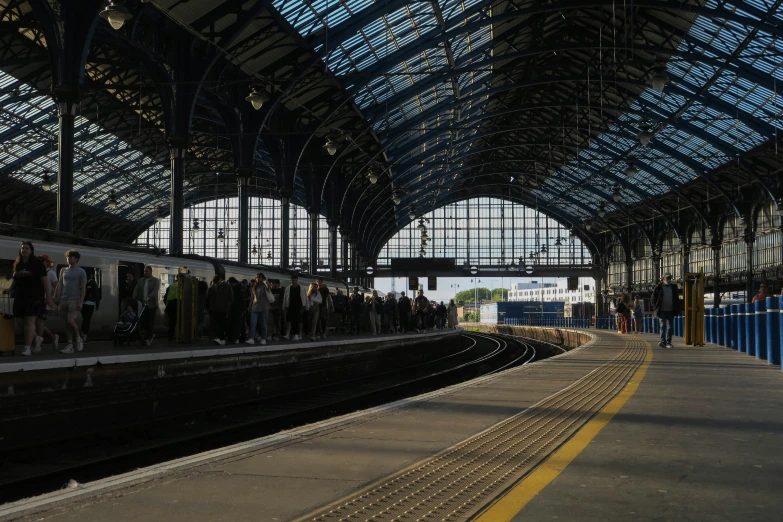 a group of people standing at a train station as one prepares to board