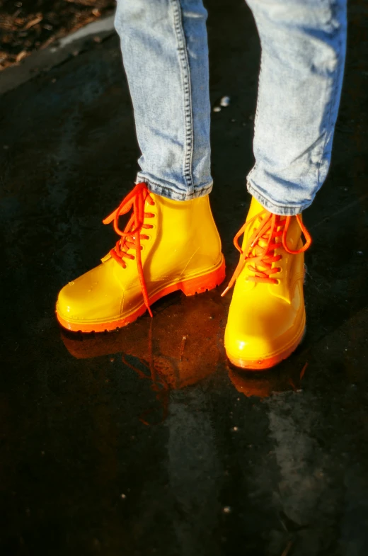 a person in yellow rain boots standing on the ground