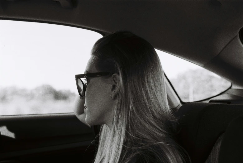 a woman in the back seat of a car driving