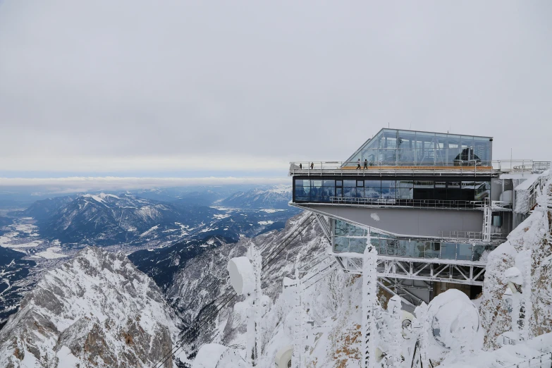 a building is at the top of a mountain while covered with snow