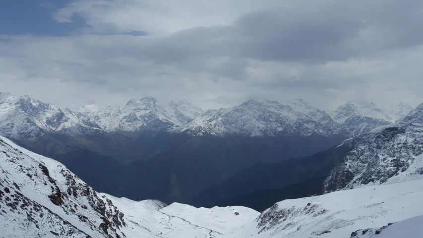 a view from top of a snowy mountain looking down on some very snowy mountains