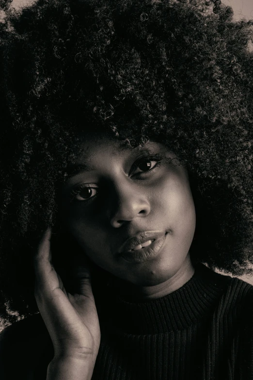 a woman with an afro looking into the camera