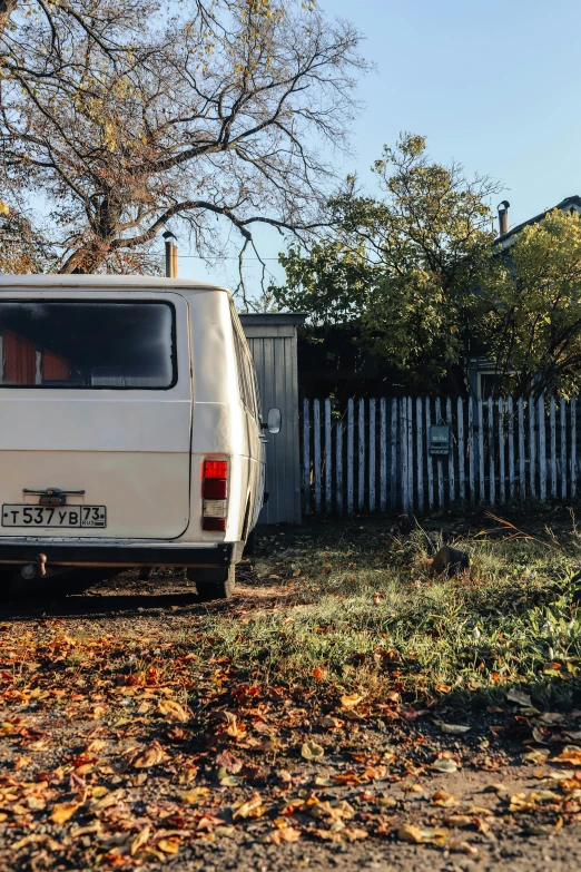 there is a white van parked near a fence