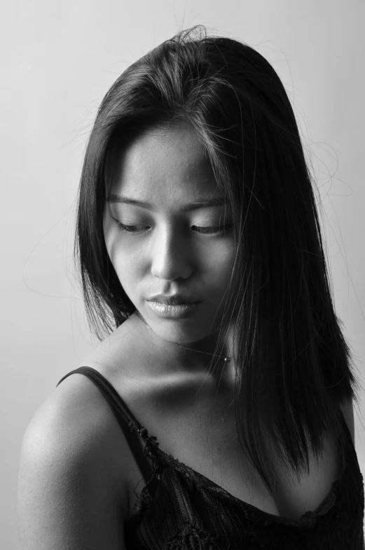 a woman standing in front of a white wall with her eyes closed