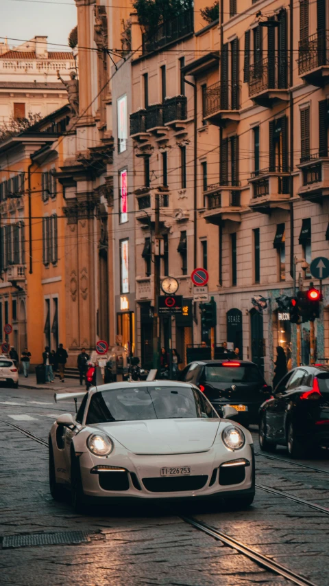 a car sits at a traffic light next to some buildings