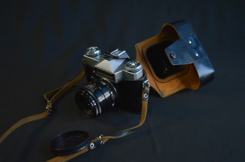 a camera and a small bag on a black table
