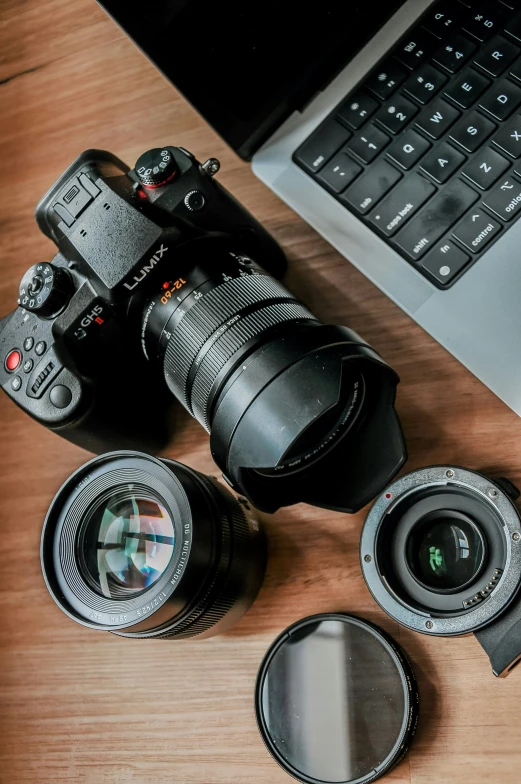 camera with the hood off and lens cap cover on a table