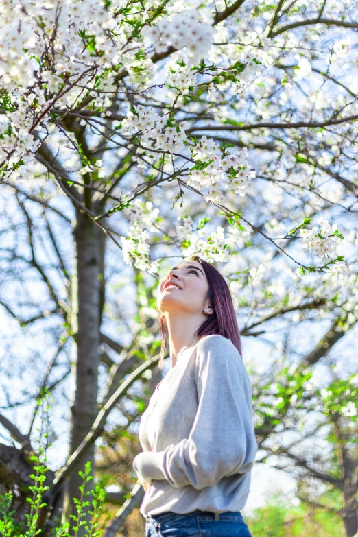 a woman is enjoying the spring in the woods