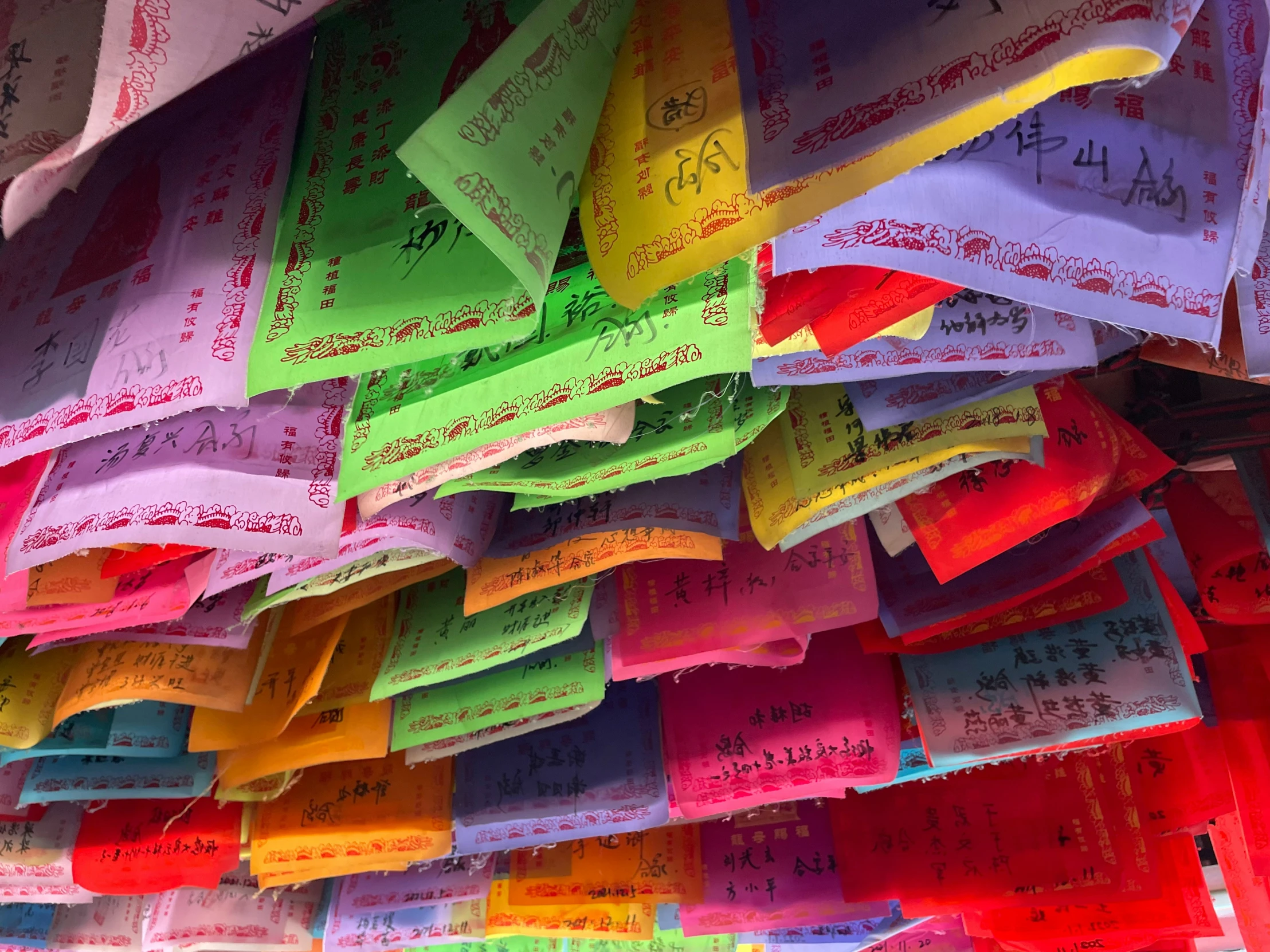 the colors of paper are hanging from a wall