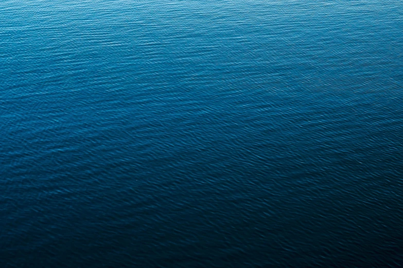 a lone boat is seen in the blue water