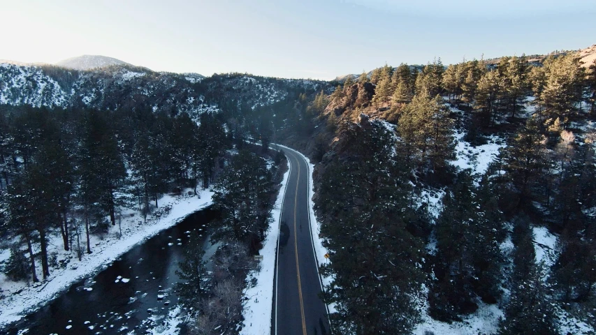 an aerial view of a road in the middle of a snowy mountain