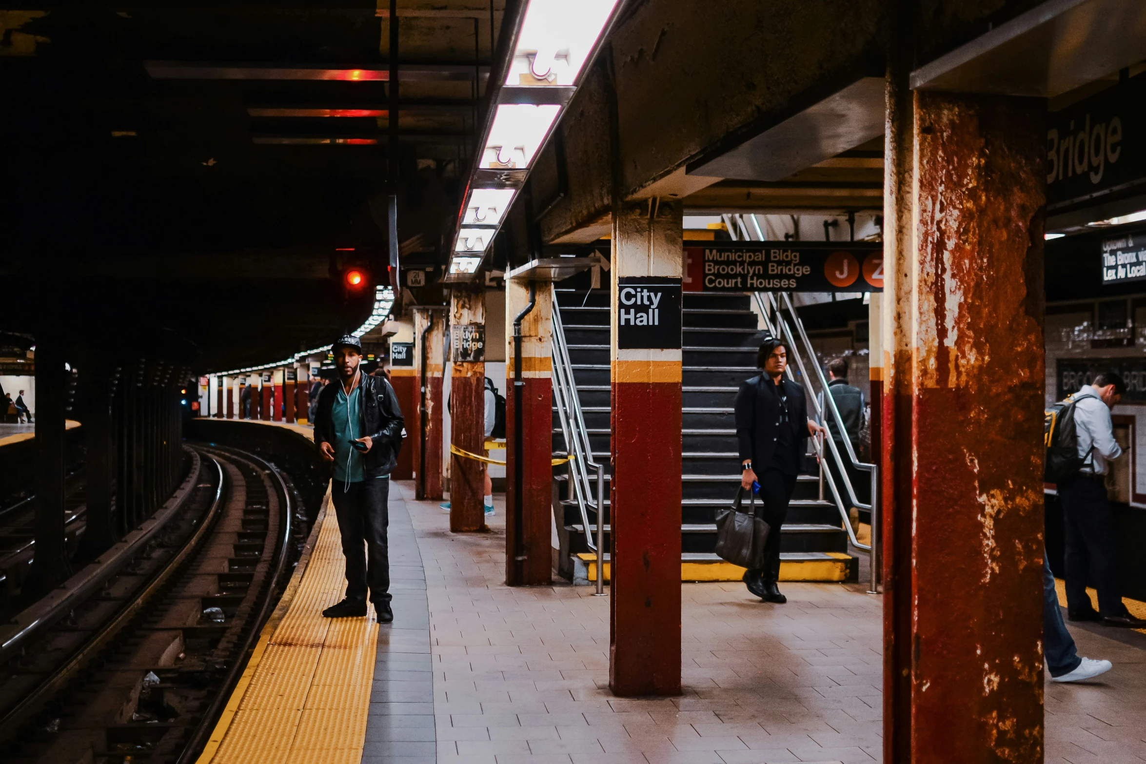 people wait for a train at the train station