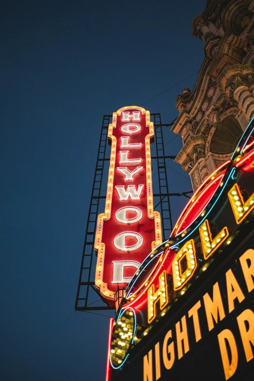 a neon sign and a tower are in the dark