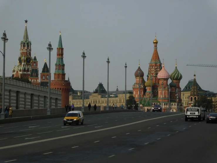 many traffic traveling on the road by some colorful buildings