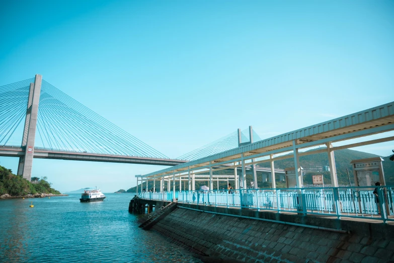 people on a boat in front of a large suspension bridge