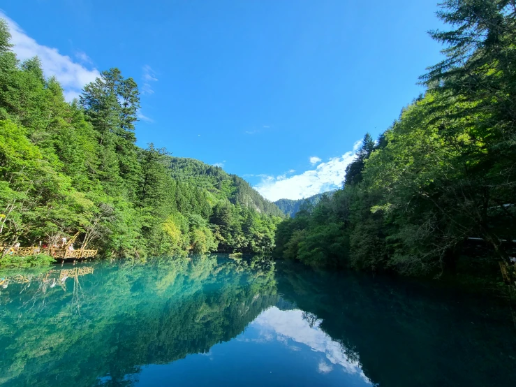 the water is blue with clear clouds in it