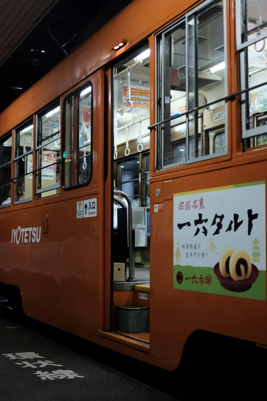 an orange subway car parked at a train station