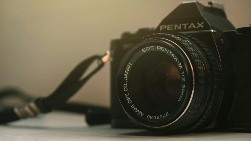 an old camera on a table with one lens attached