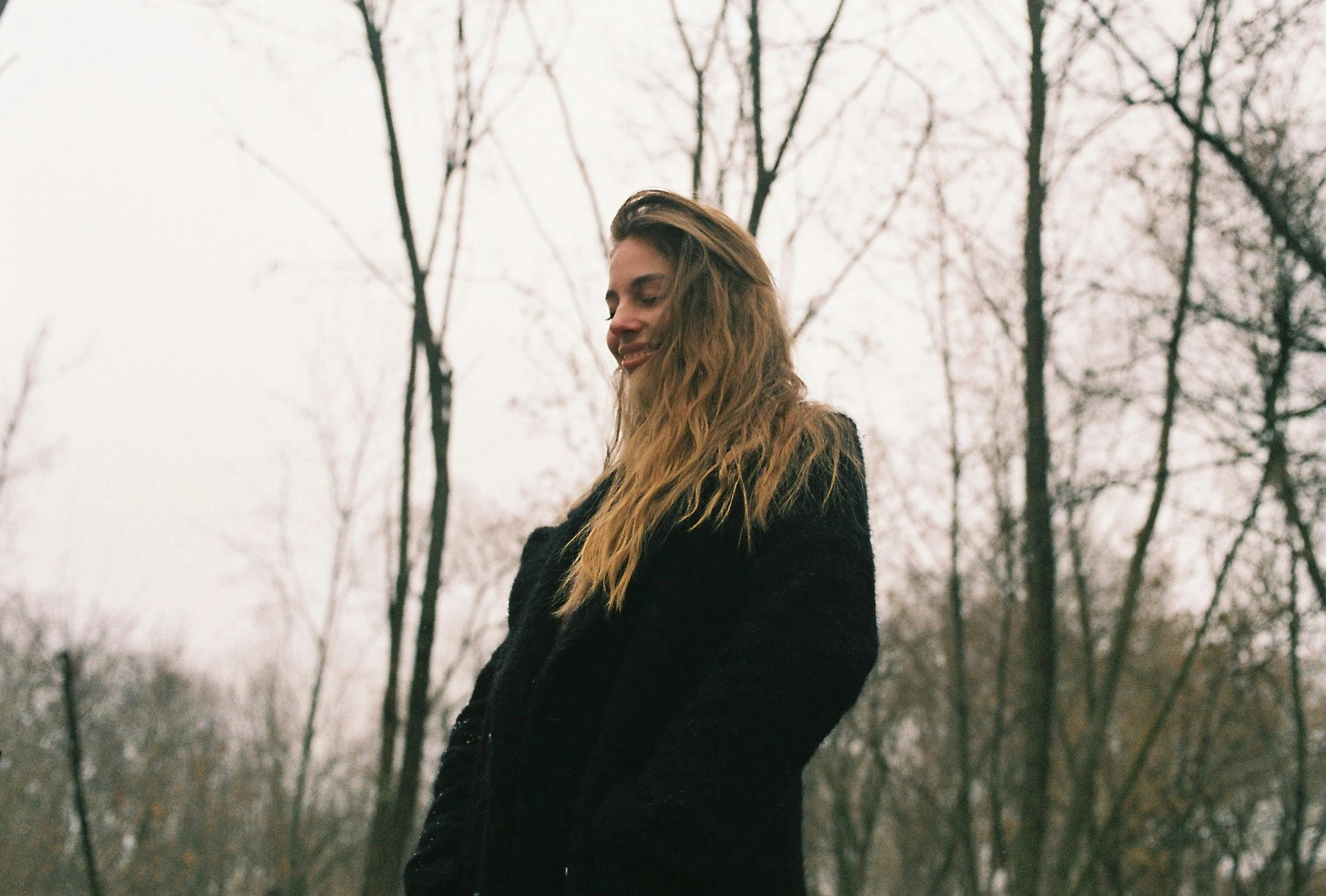 the young woman is wearing a black jacket and a frisbee in her hand