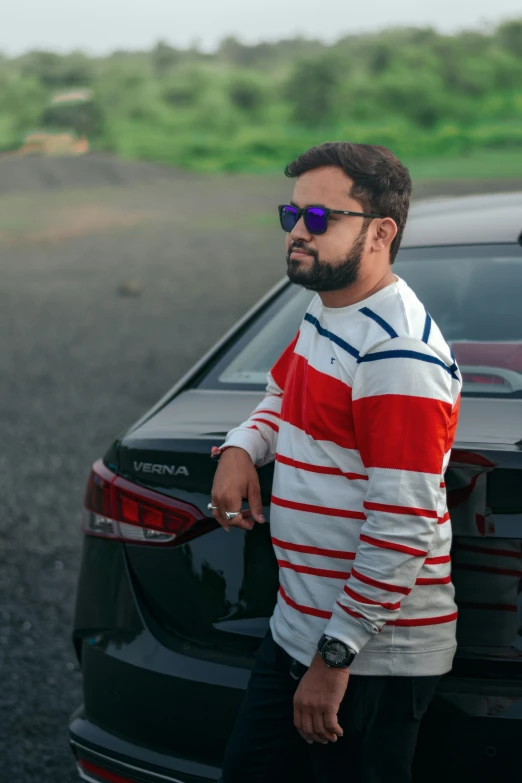 the man is standing next to a parked car