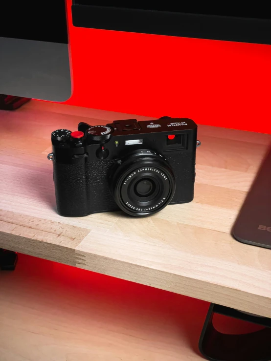 a digital camera on a wooden shelf next to an ipod