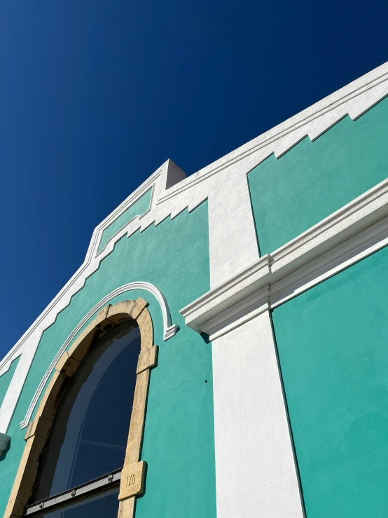 blue sky over green building with a window