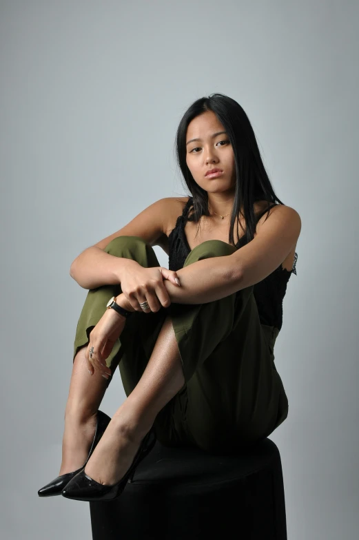 a young woman with long dark hair sitting on a chair