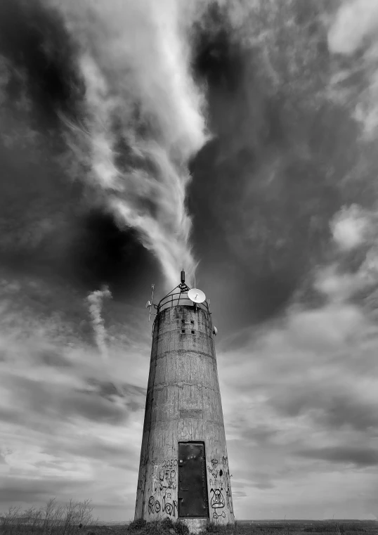 a large stone lighthouse stands in the middle of a grassy field