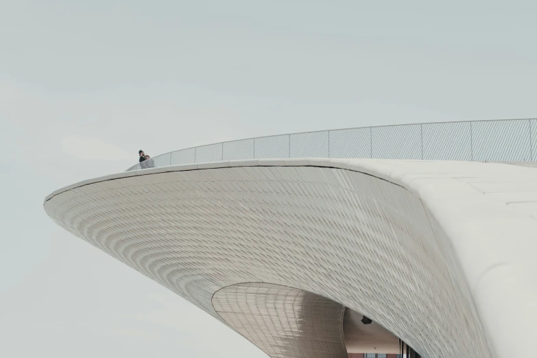 two people standing on a white roof with white bricks