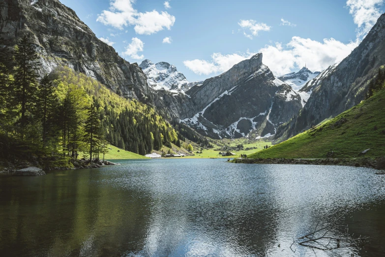 the mountains surrounding the lake are covered in snow