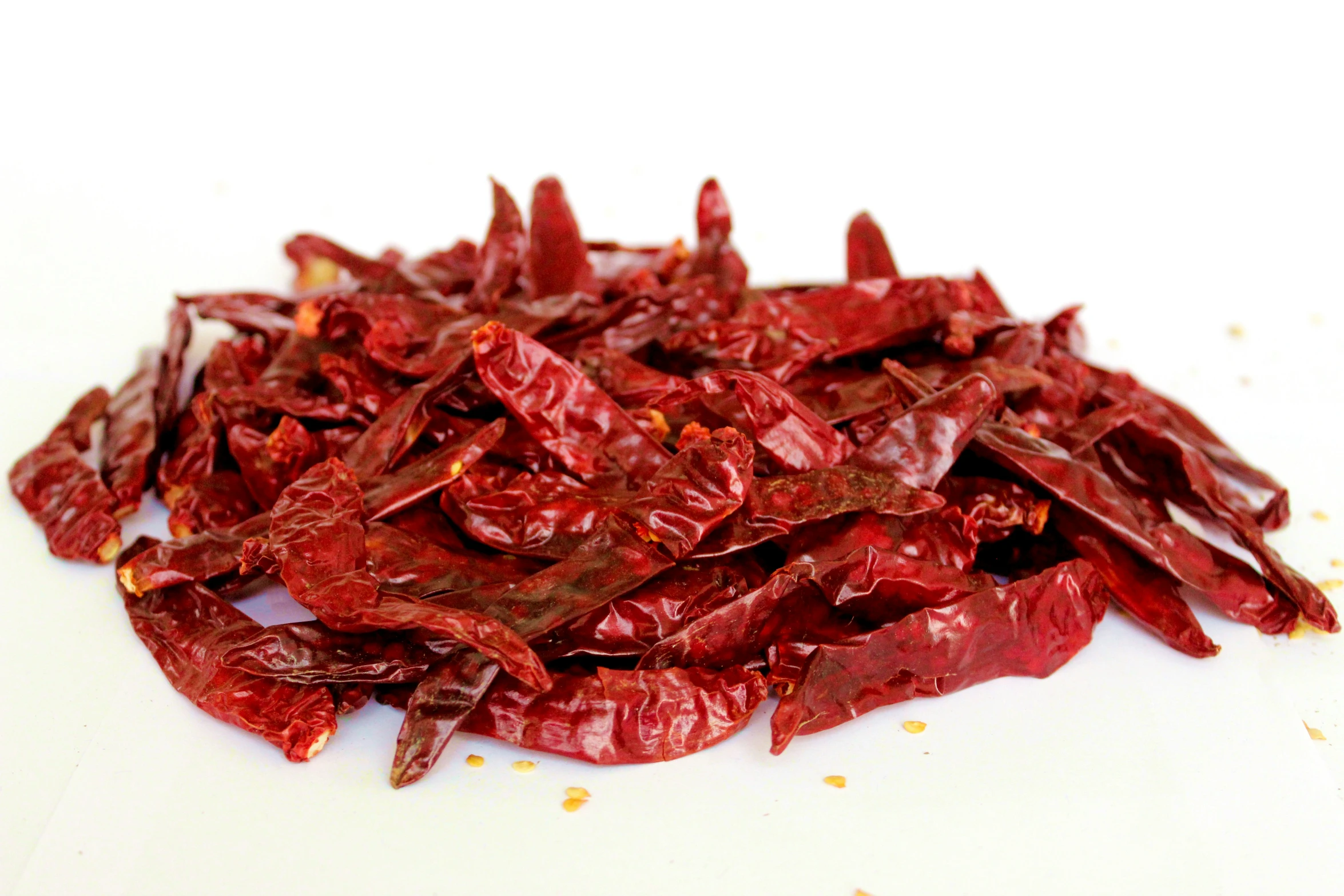 a pile of dried red chili sitting on top of a white surface