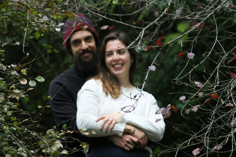 a couple holding each other in the woods