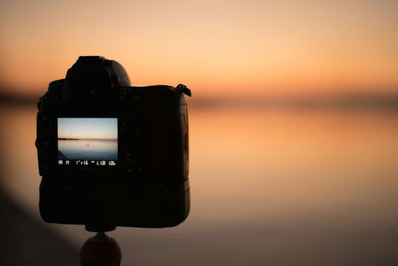 a camera set up in front of a very wide body of water
