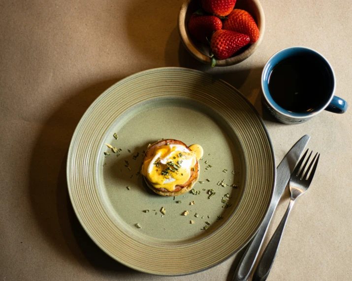 the table is holding a plate of food and coffee