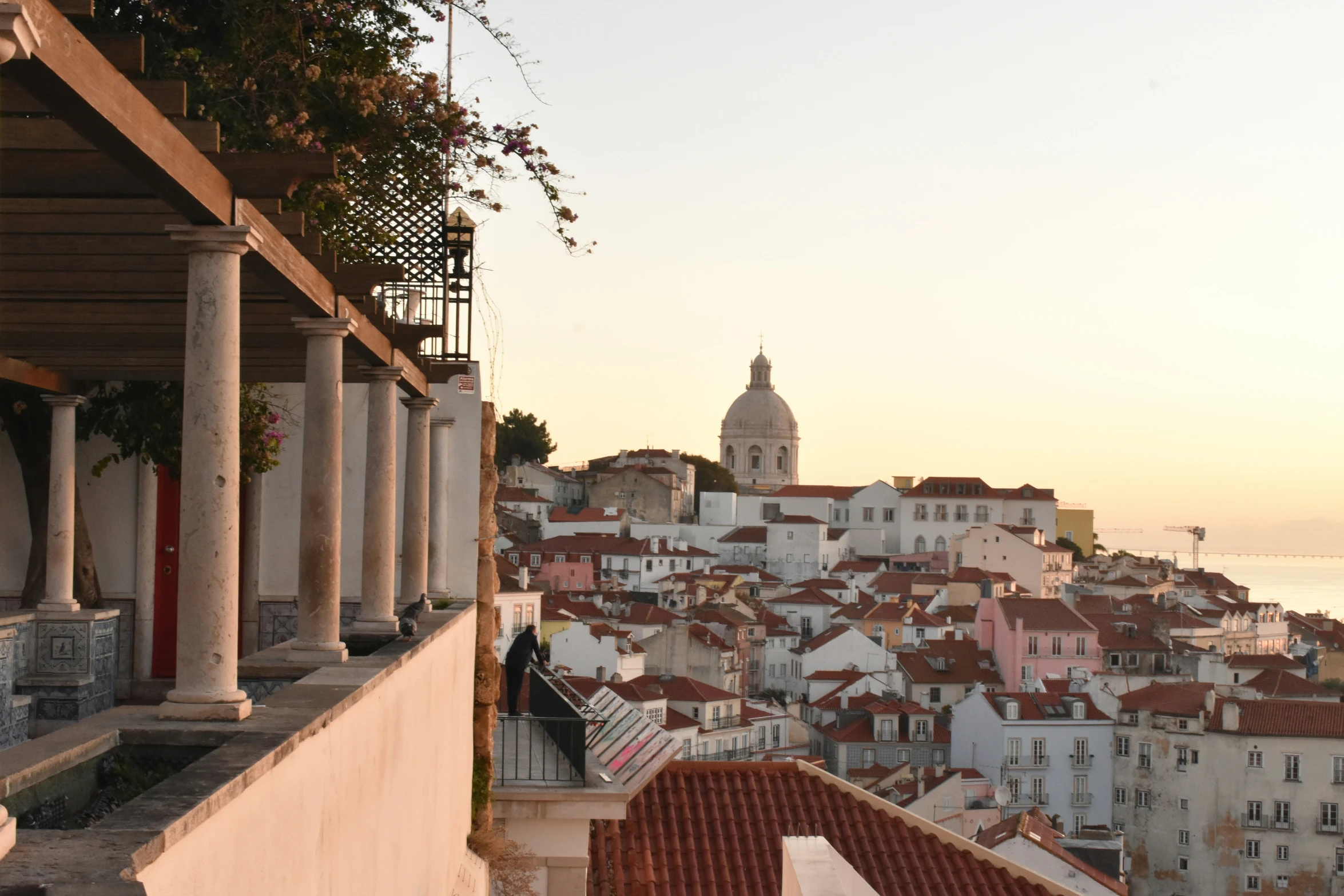 two people sit at a balcony overlooking some buildings