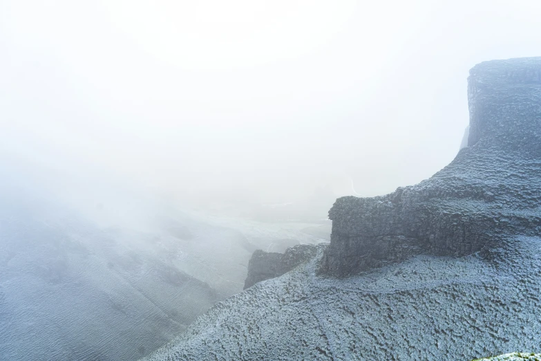 fog hangs over a mountainous landscape on a hill