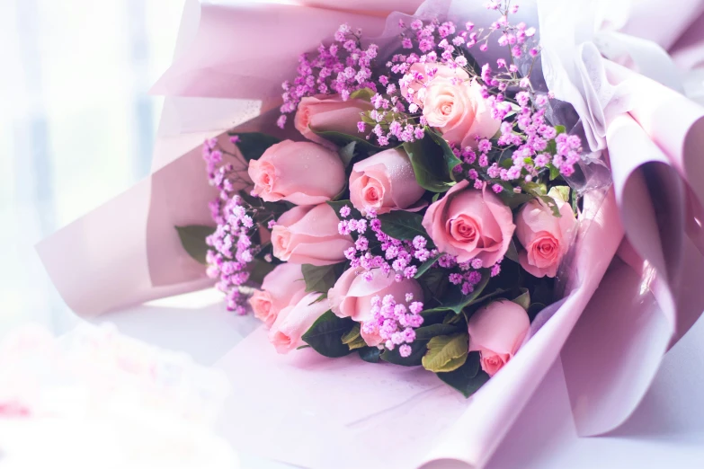 a pink bouquet is wrapped in pink and purple paper