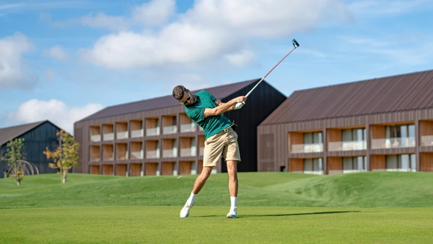 a man hitting a golf ball with a club on a green