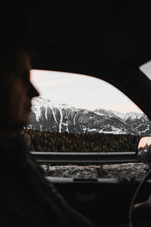 a view from the inside of a vehicle shows mountains and woods