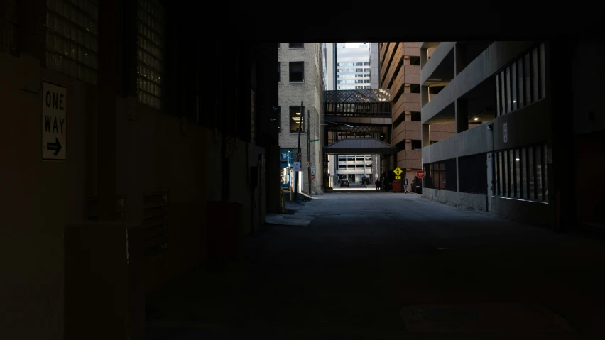 alley way in an industrial city with some lights on at night