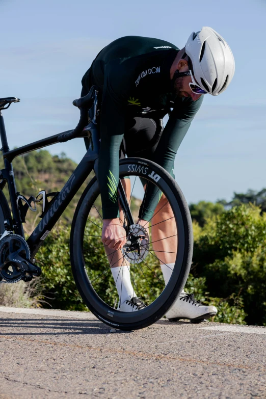 a cyclist wearing green on his bike on the road