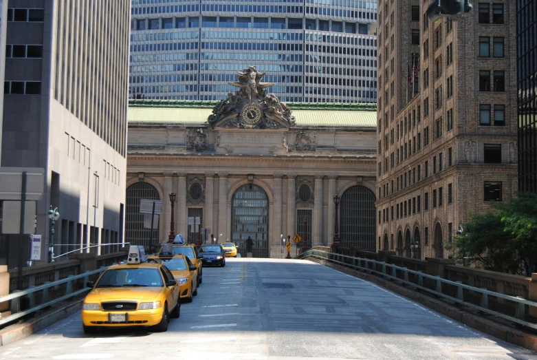 three taxi cabs are driving down the street