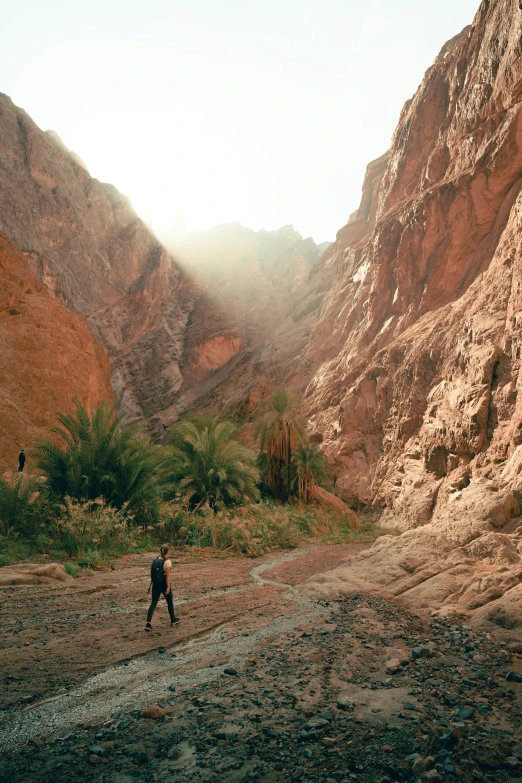 two men walking away from each other through a rocky mountain valley