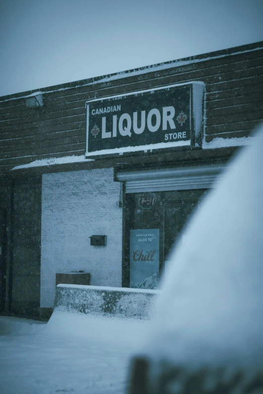 a liquor store is partially covered with snow