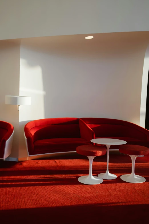 an orange couch and two white tables in a room